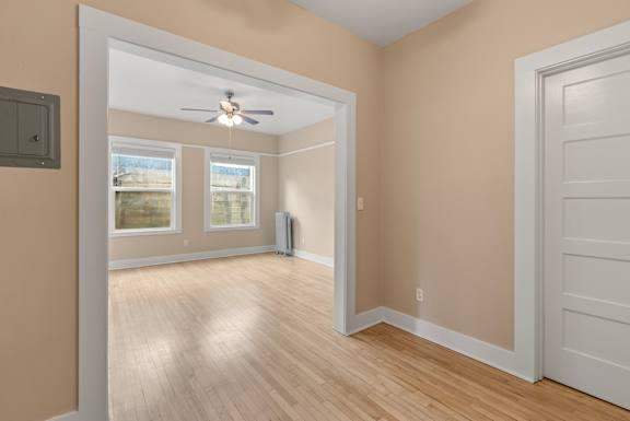 A room with a ceiling fan and a window.