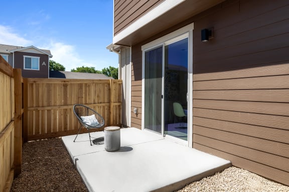 a patio with a chair and a sliding glass door