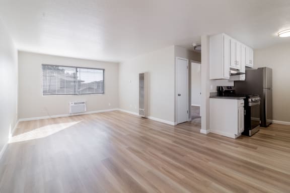the living room and kitchen of an apartment with a hard wood floor at Alturas Paso Robles Apartment Homes, Paso Robles, 93446