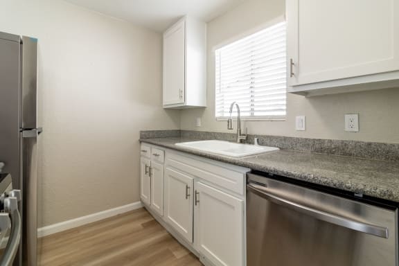 an empty kitchen with granite counter top and stainless steel appliances at Alturas Paso Robles Apartment Homes, Paso Robles