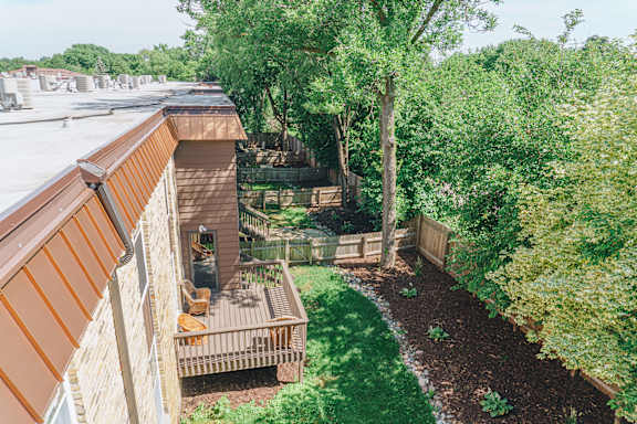 A backyard with a deck and a tree at Astor Place of Edina Apartments , Minnesota, 55435