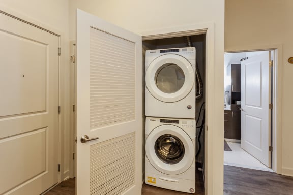 a front loading washer and dryer in a closet in a home