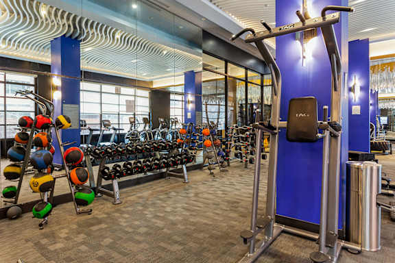 a gym with weights and cardio equipment in the lobby of a building
