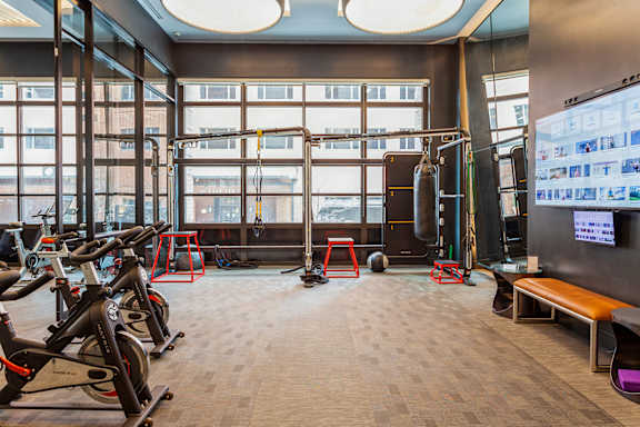 a gym with exercise equipment and windows in a building