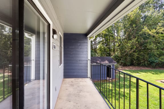 a balcony with a view of a yard and a house