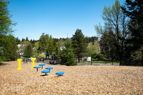 a park with a playground and blue benches at Murrayhill Park, Beaverton