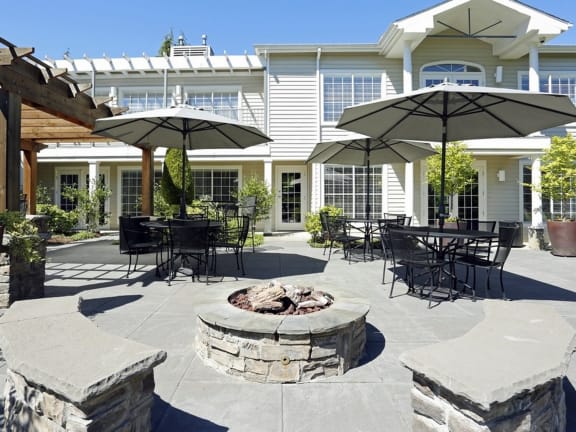 a patio with tables and umbrellas and a fire pit at Murrayhill Park, Beaverton, OR 97008