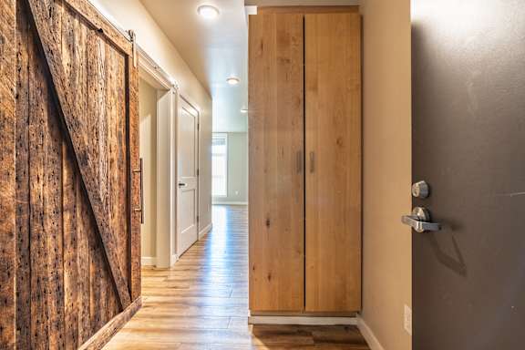 A hallway with a wooden door on the right.