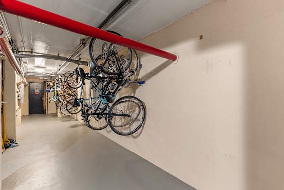 A bike rack with several bicycles hanging on it.