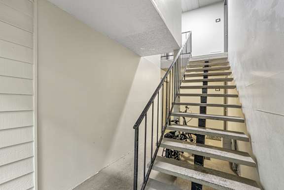 A staircase with a metal railing and wooden steps.