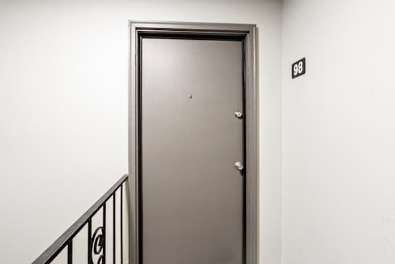A closed door with a number 98 on the wall behind it.