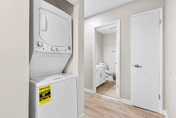 A white dryer is in a room with a white door.