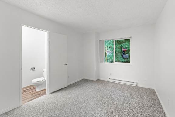 A white bathroom with a toilet, sink, and window.