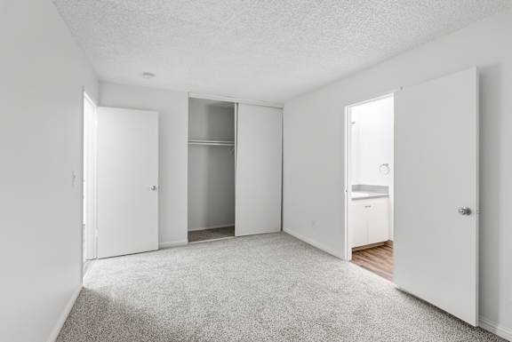 A white room with a carpeted floor and a white door.