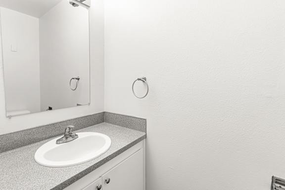 A bathroom with a sink and mirror.