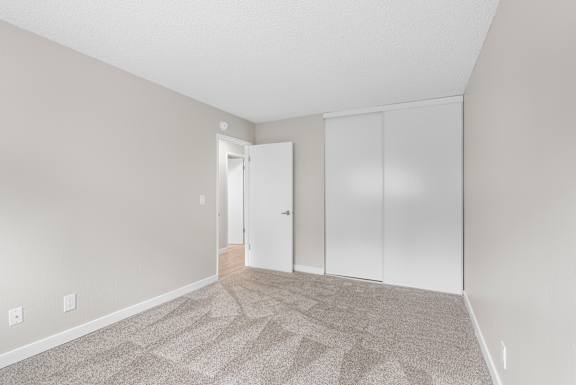 A room with a carpeted floor and a white door.