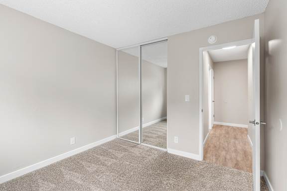A room with a carpeted floor and a sliding glass door.