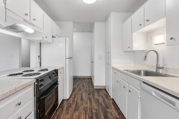 A kitchen with white cabinets and a black stove top oven.