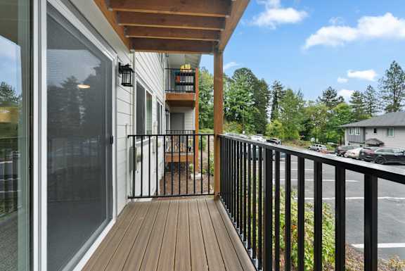 A balcony with a black railing and a wooden floor.