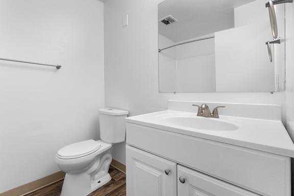 A white toilet and sink in a bathroom.