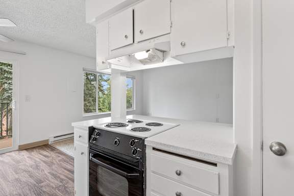 A white kitchen with a stove and oven.