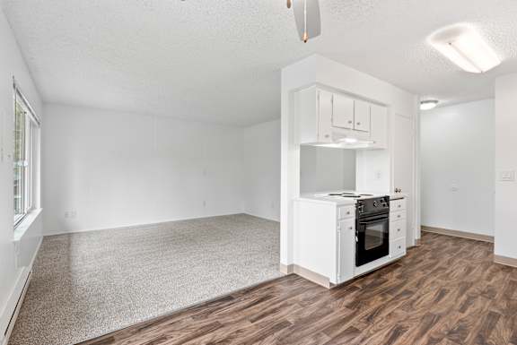 A small kitchen with a white cabinet and a white oven.