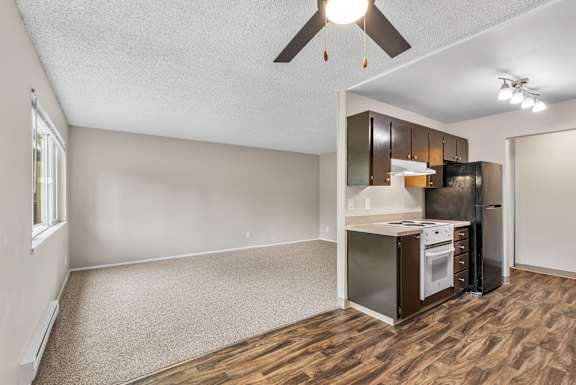 A kitchen area with a stove top oven and a refrigerator.
