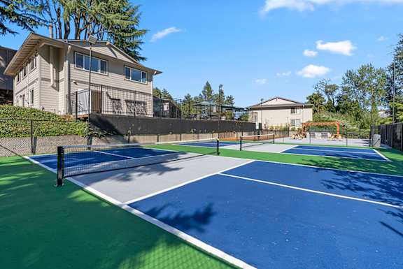A tennis court with a green and blue surface and white lines.