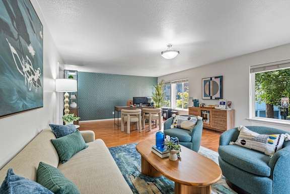 A living room with a couch, chairs, and a coffee table.