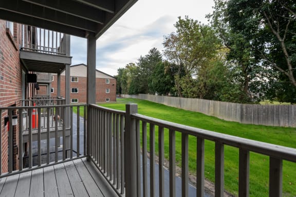 the view of a yard from the deck of a home with a porch at Flats at Merrill Pond, Worcester, MA 01607