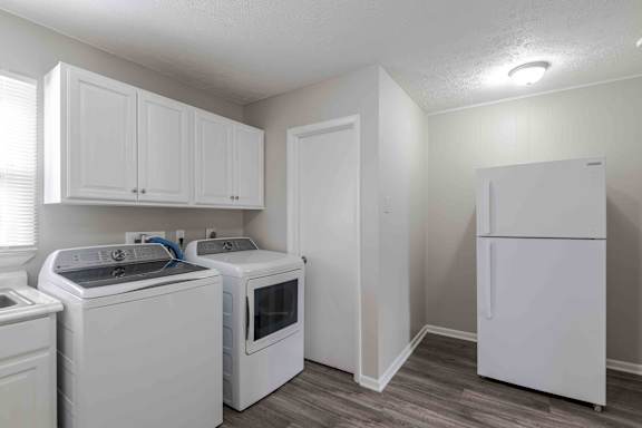 a white kitchen with white appliances and a refrigerator
