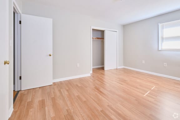 an empty living room with wood flooring and a closet at Fay Street Apartments, Winchester, 22601