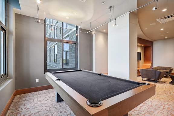 a games room with a pool table and a window