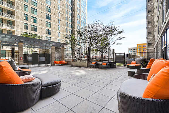 an outdoor patio with chairs and tables and a building in the background
