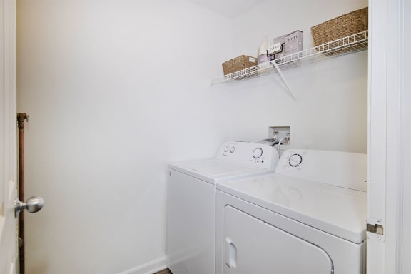 a white washer and dryer in a room with a white door  at Ascent at Farmington Hills, Michigan