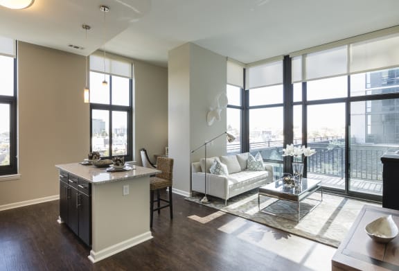 a living room with a couch and a table in front of windows