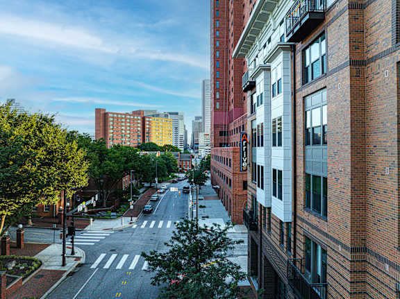A city street with buildings on both sides and a crosswalk in the middle.