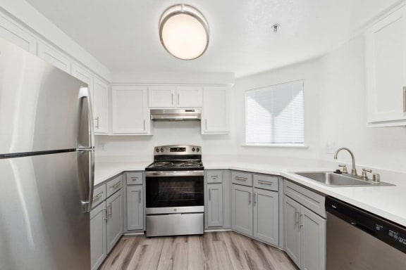 A modern kitchen with a stainless steel refrigerator and a stove top oven.
