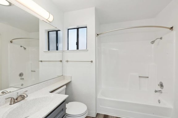 A white bathroom with a toilet, sink, and bathtub.