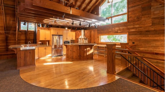 A large open kitchen and living room with wooden floors and cabinets.