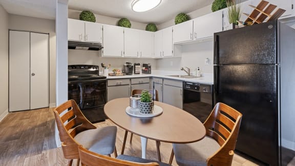 A kitchen with a table and chairs.