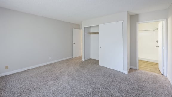 A room with white walls and a grey carpet.