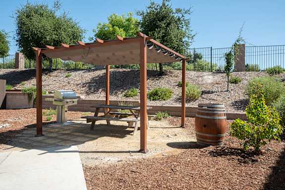 a picnic table in a park with a wooden canopy