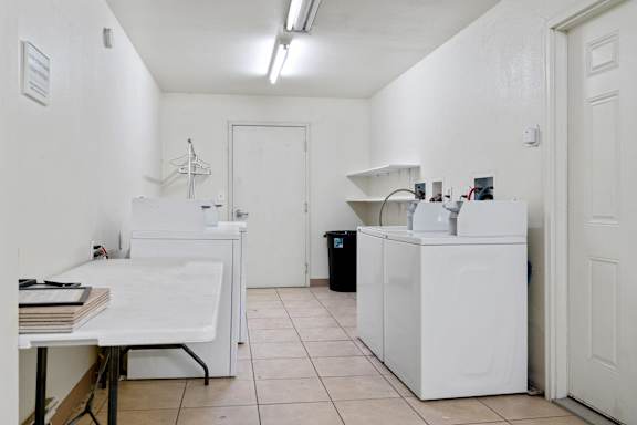 a laundry room with two washing machines and a table