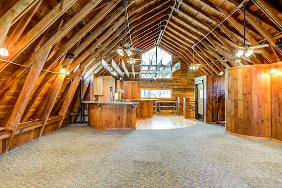 an open floor plan with a kitchen and dining area in a timber frame barn