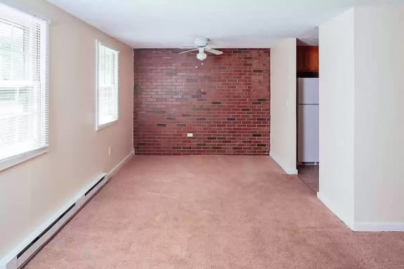 the front of a brick house with a gravel yard and a deck