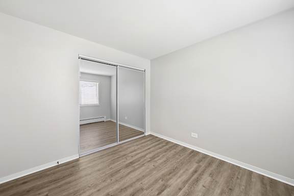 A room with a sliding glass door and wooden flooring.