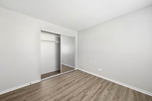 A room with a sliding door and wooden flooring.