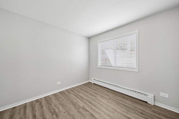 A room with a window and a radiator on the wall.