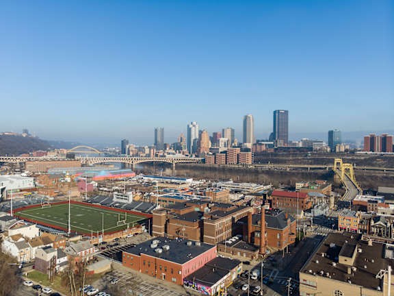 an aerial view of the city with a football field at Residences at South High, Pittsburgh Pennsylvania ?